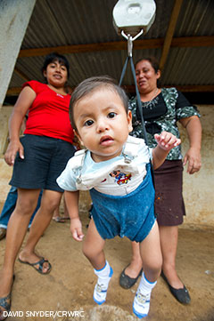 a baby gets weighed in Guatemela