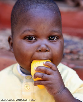 Baby munching on fruit