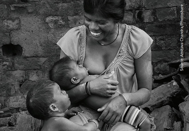photo of woman breastfeeding baby next to toddler
