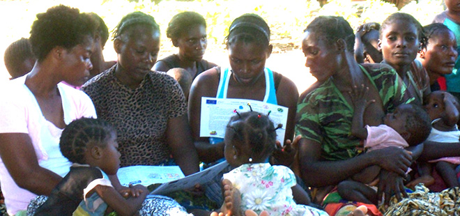 Women with children sit together reading