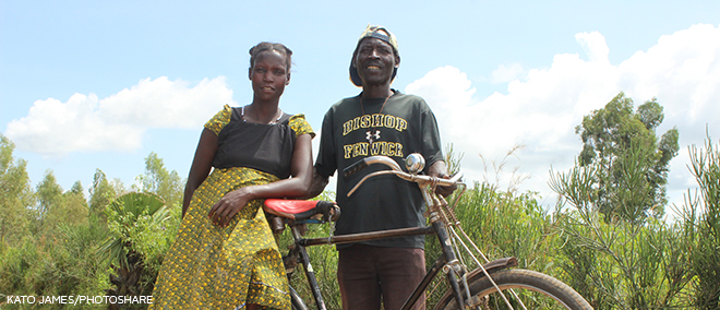 Man and woman with bike by a field