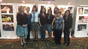 group posing in front of wall of photos