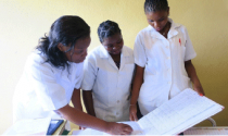 Photo of nurses in Mozambique looking at a health register.