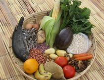 Basket full of variety of foods like fish, grains, and leafy vegetables.