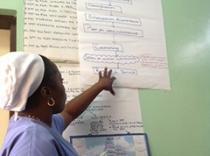 A NACS coach shows a process diagram to help staff at a health facility in Kinshasa identify issues with implementation.