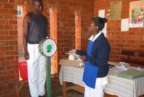 A client is weighed at a clinic.